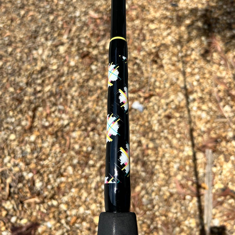 Load image into Gallery viewer, Built like our Fin #18, this spinning rod comes with Fuji alconite guides, EVA foam grips, Fuji reel seat, and metal gimble. Butt Wrap showing. All black blank with yellow trim. &quot;egg shaped&quot; wrap with teal, white, pink and yellow.  Side view.
