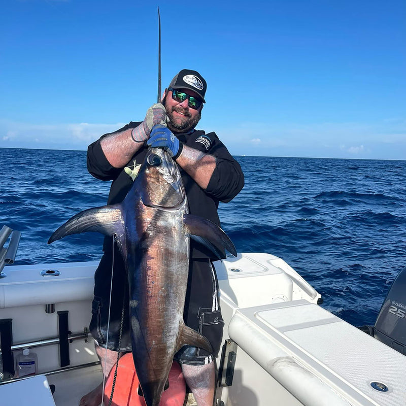 Load image into Gallery viewer, Chris of @ChefOutdoors sporting his Blackfin Black and dark gray trucker hat with the monster Swordfish he caught.