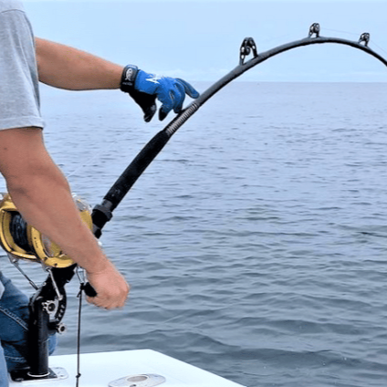 Load image into Gallery viewer, T-10x Adjusta-butt in black shown in action on the water. With a Penn 130 class reel in gold, and a 130 class all black rod.